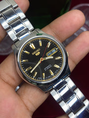 Seiko 5 Automatic — Black & Gold Dial Watch with Exhibition Back | Ref 7S26-01T0.